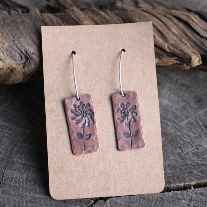 Flower with many petals stamped on rectangular copper earrings
